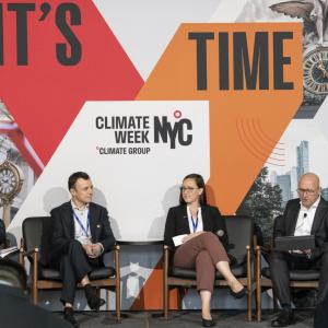 Four people seated in chairs on a stage 