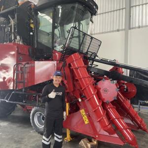 A person stood next to agricultural machinery 