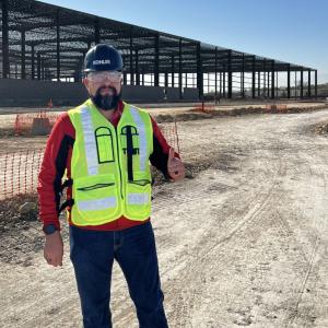 Person standing outside in hard hat and reflective vest