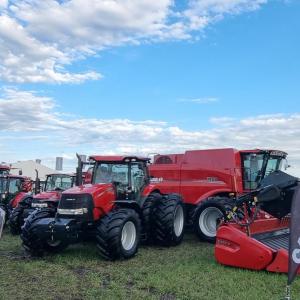 Tractors and equipment in a field under a cloudy sky