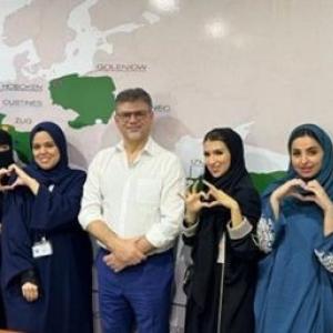 A large group photo of people make love heart signs with their hands