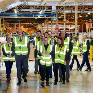 People in reflective vests walking through a plant