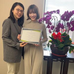 Two people standing together, holding a diploma