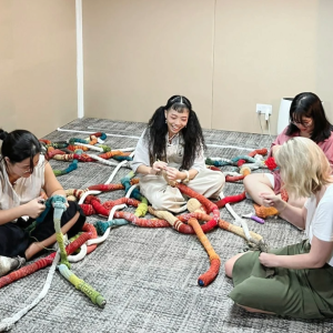 People sitting on the floor working on something together