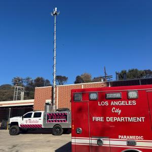 Emergency and T-Mobile vehicles in front of a building