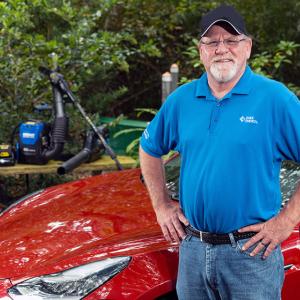 Hamilton in front of electric car