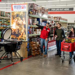 a Tractor Supply employee helping a couple locate an item in store