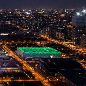Beijing at night with a building lit in green