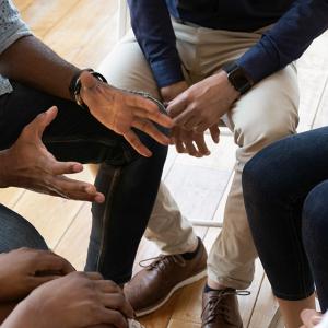 hands, arms and legs of patients sitting in a close circle