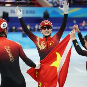 three athletes hold the Chinese flag