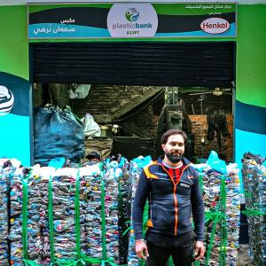 Person standing among piles of plastic to be recycled