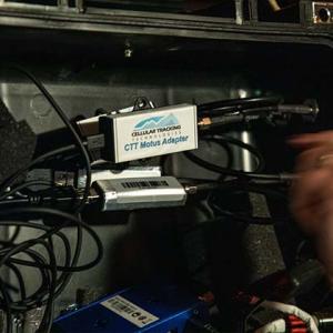 a dark cabinet with wires and a Motus tower adapter