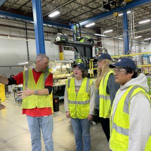 Group of people in hi-visibility vests in a factory