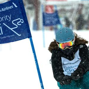 Person skiing next to a "celebrity ski" banner