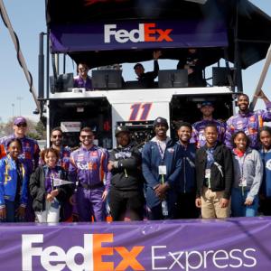 People standing together behind FedEx Express banner