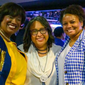 3 people smiling at a graduation