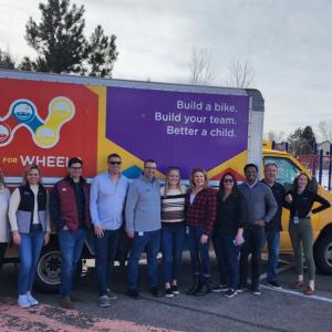 Arrow employees pose in front of a Wish for Wheels truck
