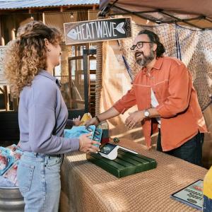 Client speaking with a business owner at a booth.