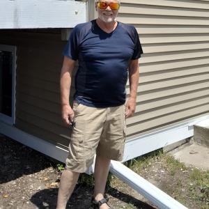 Mark shown in front of his home.