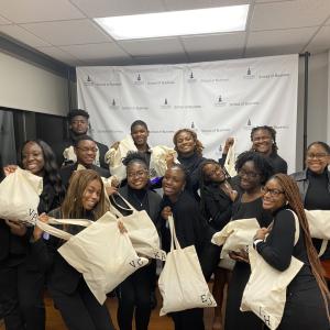 A group of M·A·C 21 CAP students holding matching tote bags