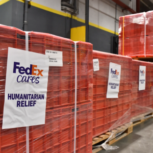 Humanitarian Relief in red crates with a sign that reads "FedEx Cares" 
