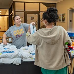 Cleveland Cavaliers volunteer handing out bags of food to members of the community.