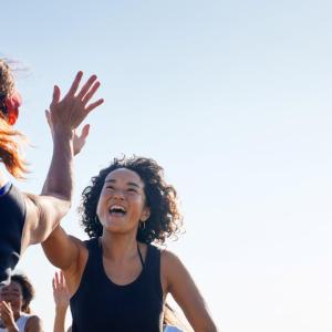 Two people high-fiving outside