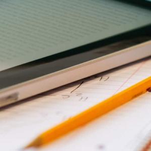 a tablet and a pencil and notebook