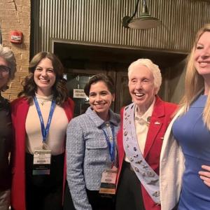 5 people with Daisy (center) at the 2022 WAI conference.