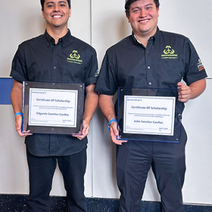 Two people standing together holding certificates