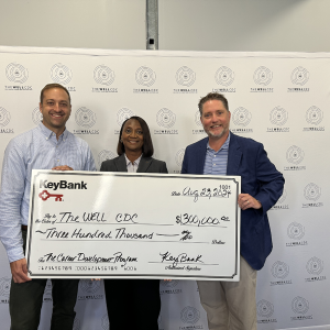 Three people posing with an oversized check