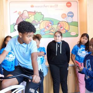 Students watching another student on a bike