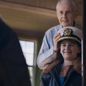 An adult putting a military hat on a child 