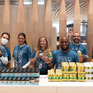 Group holding cans and smiling