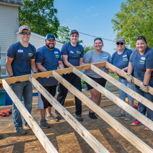 People raising a wall frame together