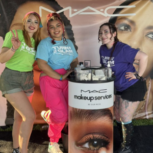 People standing together in front of a MAC banner