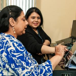 Syeda and her sister Darakhshan using a tablet PC