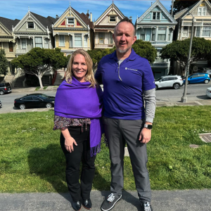 Two people standing outside wearing purple