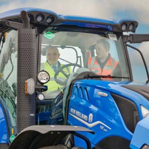 People inside the cab of a blue tractor
