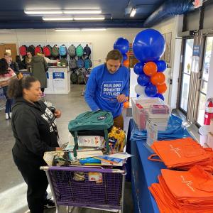 People stocking a table from things in a shopping cart