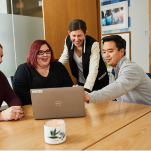 People working at a laptop together at a conference table