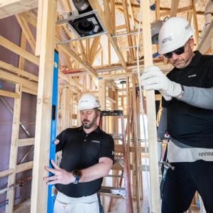 Two people framing a room in a house