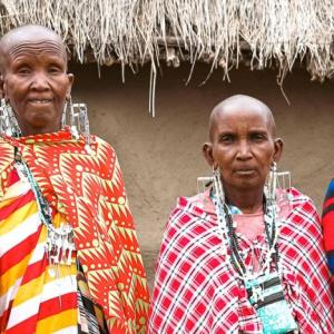 Three people stood next to each other wearing colourful clothing 
