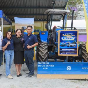 four people standing next to a tractor
