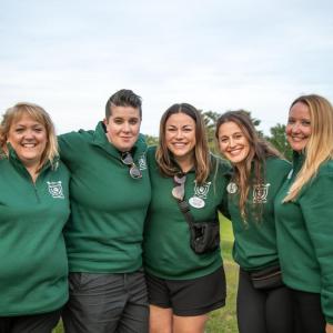 Four people in green standing together outside