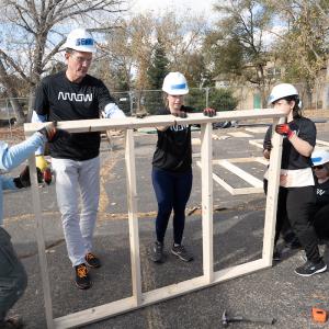 4 arrow employees put a frame together