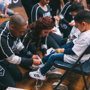 LA Kings Hockey Development Team and LA Kings Ice Crew help students put on their new shoes.