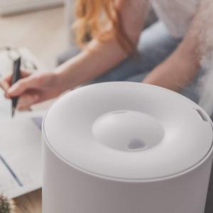 humidifier mists into the air while someone uses a computer