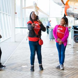 Girls watch a paper plane fly