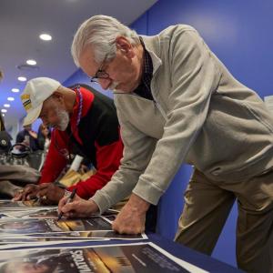 People signing posters 